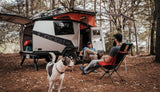 2 men and a dog in front of a TAXA Cricket