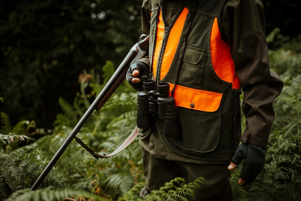 hunter wearing orange and green safety jacket