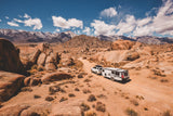 SUV pulling TAXA Overland Mantis through desert terrain